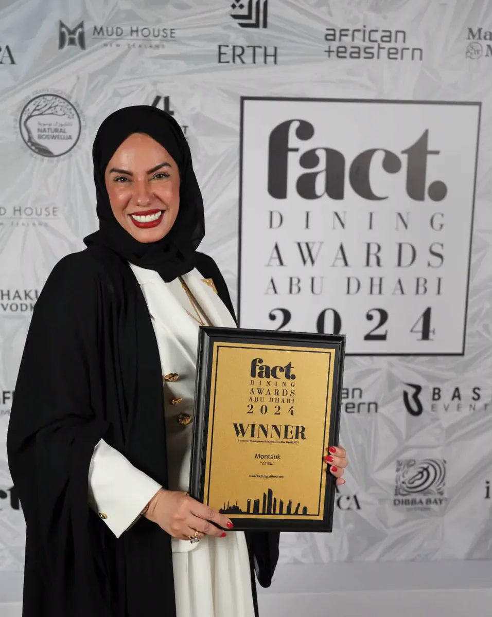 Chef Mariam Al Mansoori holding the Fact Dining Awards plaque